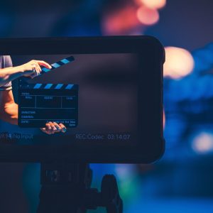 Film Production Reference Monitor. Modern Video Making Equipment. Men with Clapperboard on the Screen.